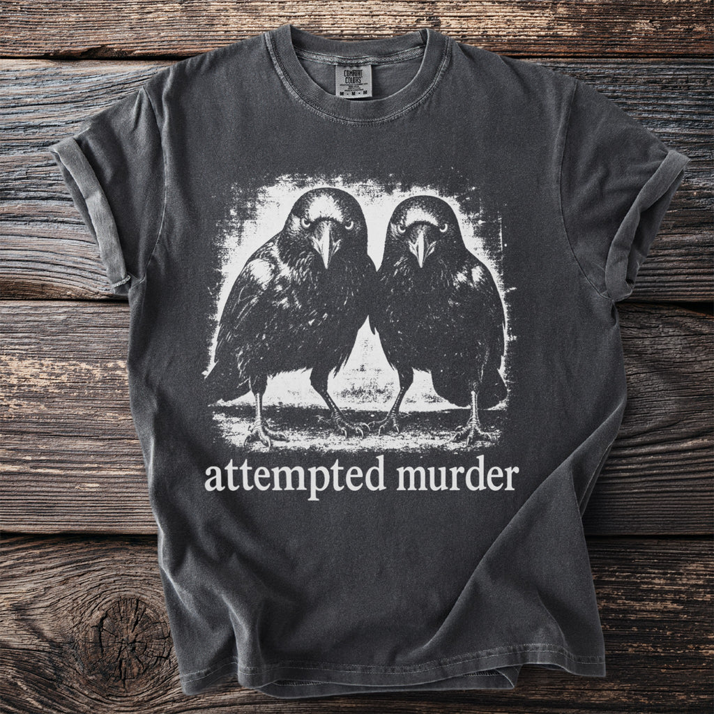 Dark gray t-shirt with a graphic of two ravens and text "attempted murder".