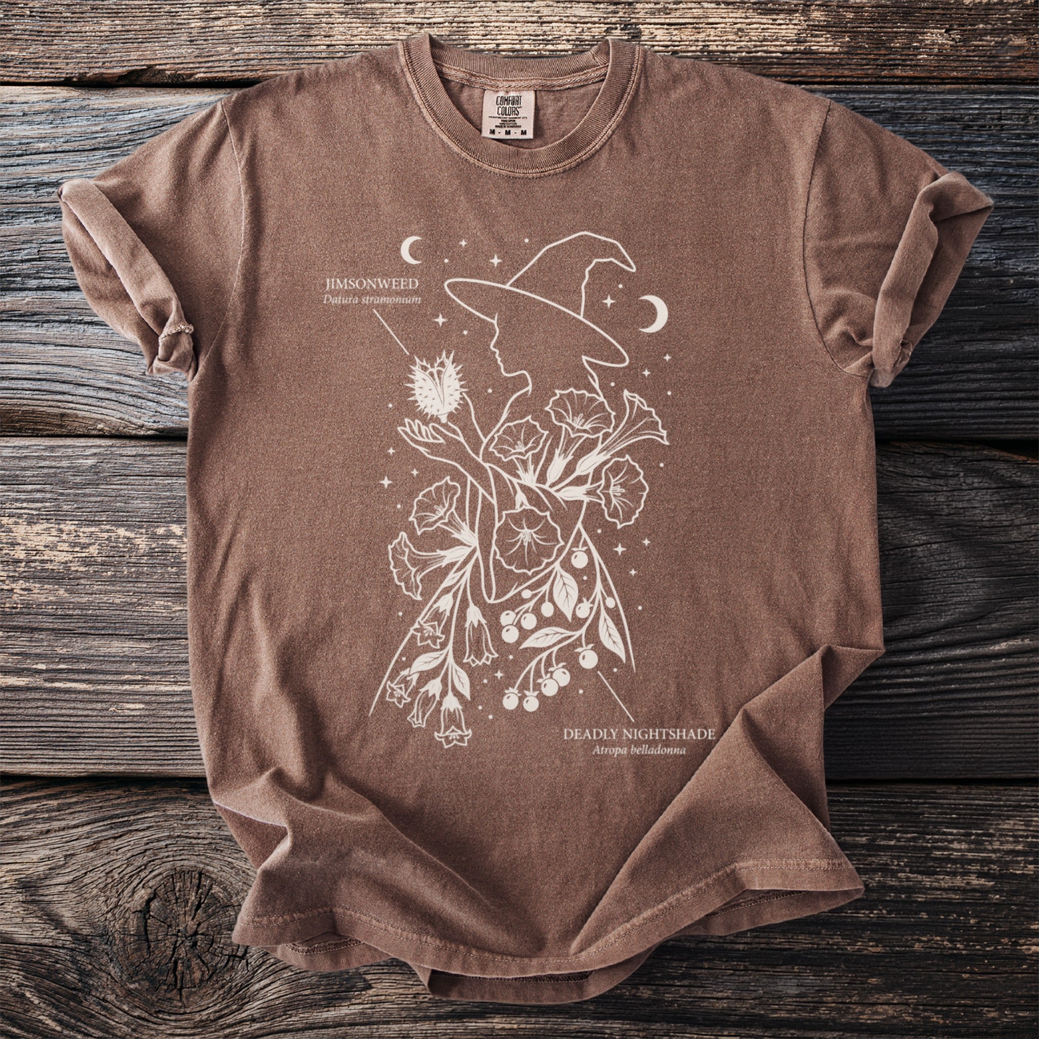 Brown shirt with witch silhouette, Jimsonweed, and Deadly Nightshade botanical illustration.
