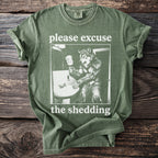 Green t-shirt with wolf illustration and text "please excuse the shedding".