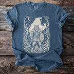Viking warrior with shield and axe, facing bear, on forested tee.