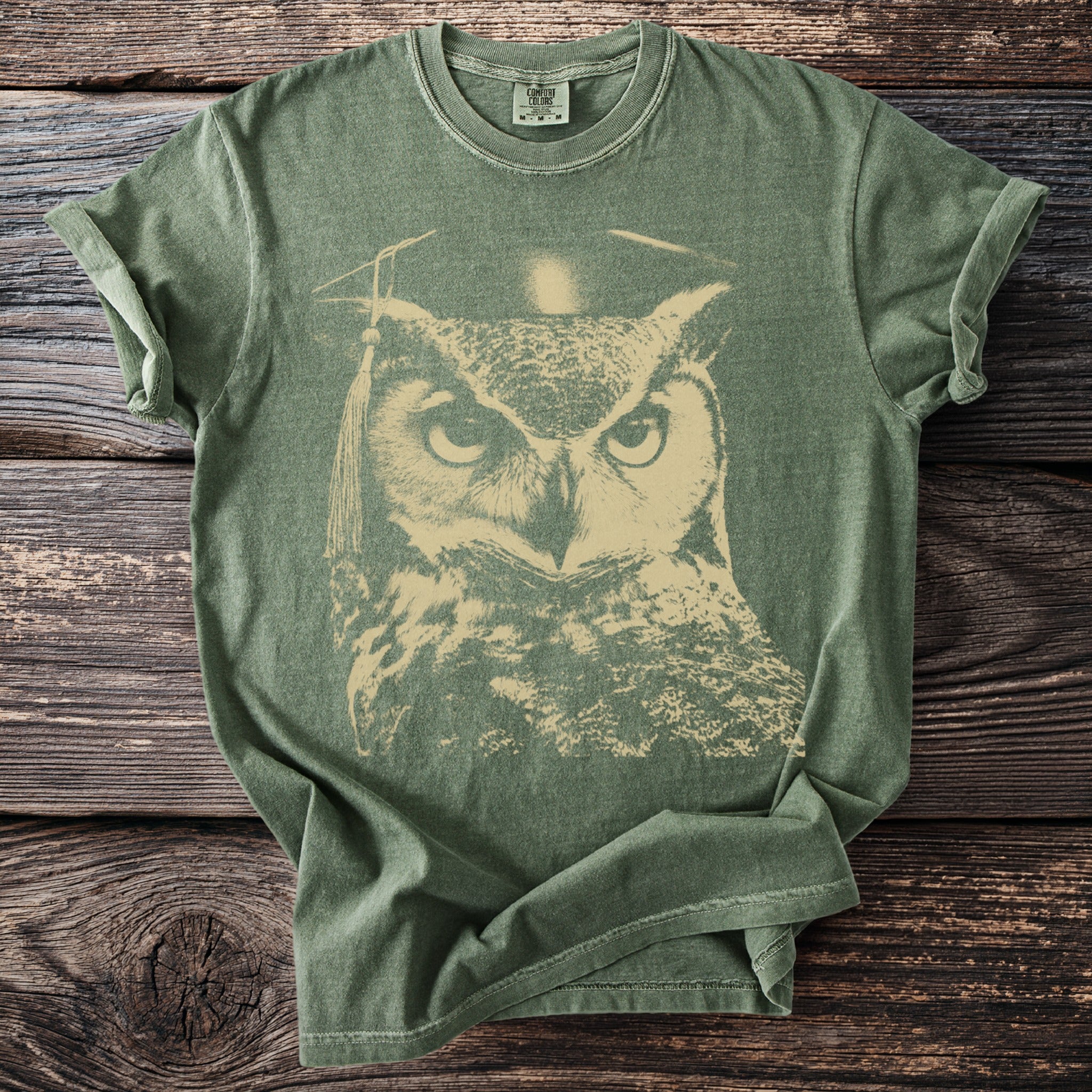Green t-shirt with a distressed print of an owl wearing a graduation cap.