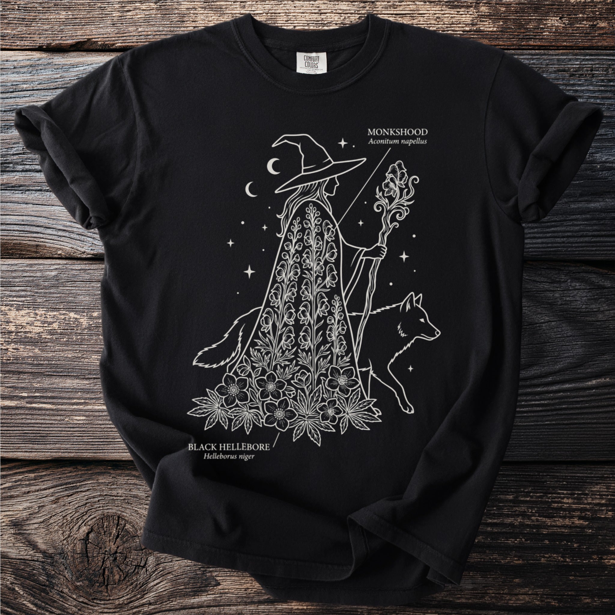 Witch with staff and dog on black t-shirt, with "Monkshood" and "Black Hellebore" text.