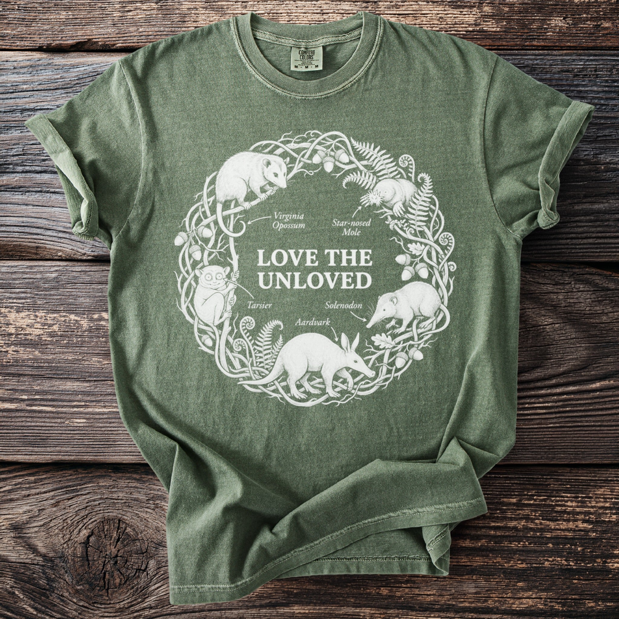 Green t-shirt with "Love the Unloved" and encircled illustration of various creatures.