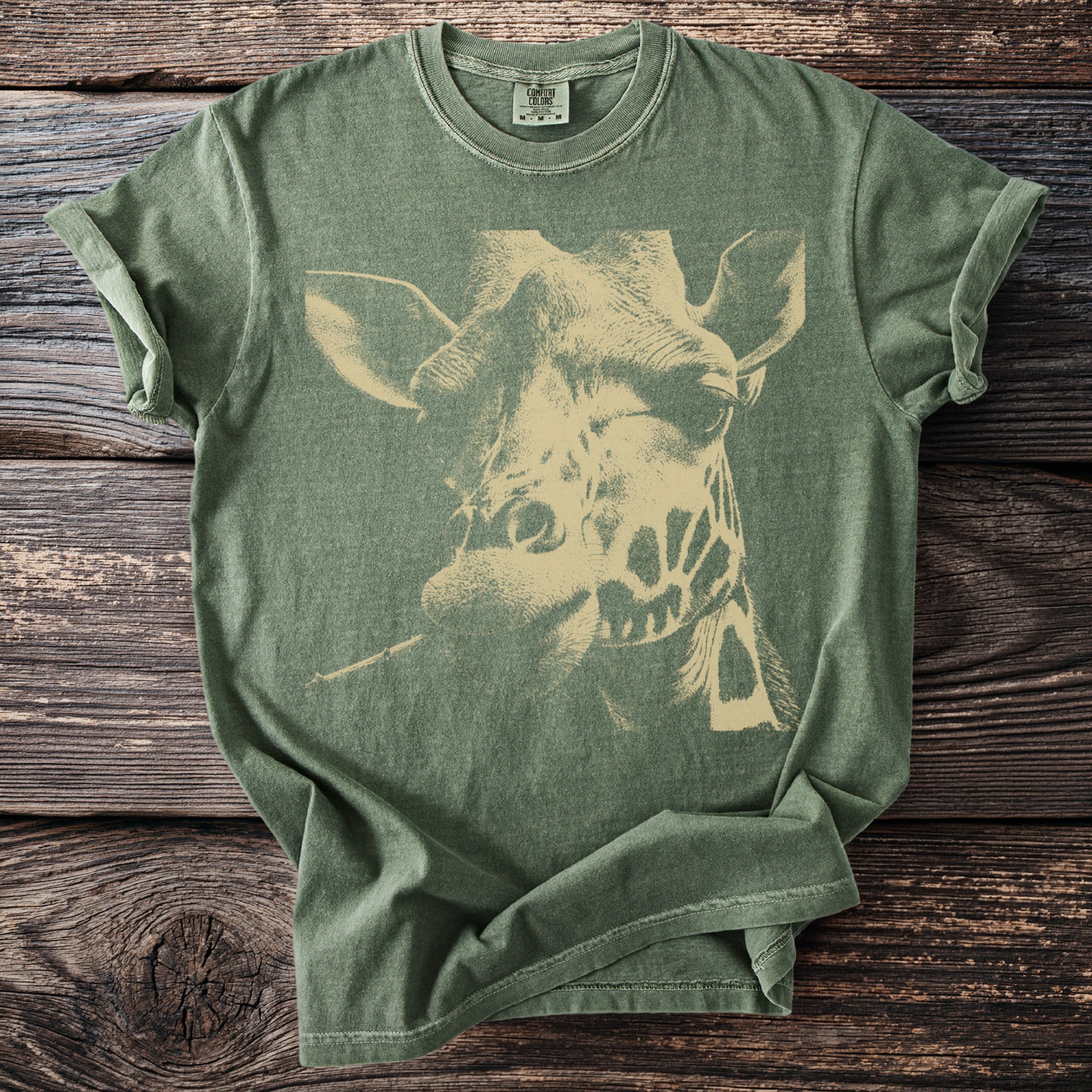 Green t-shirt with a distressed beige giraffe portrait graphic.
