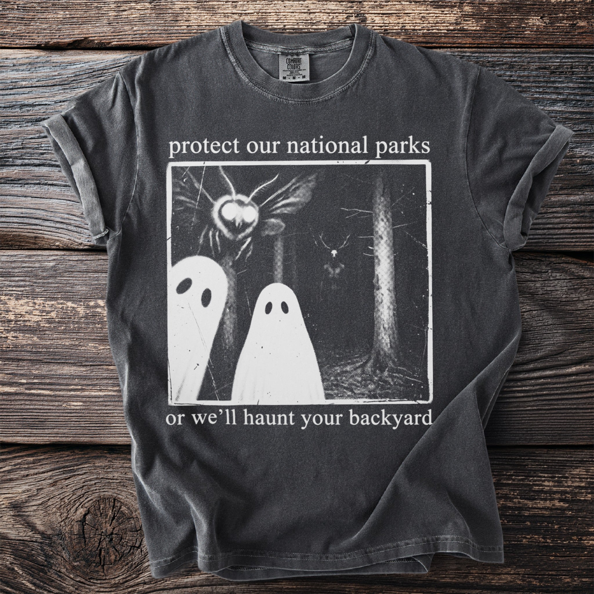 Dark t-shirt with 'protect our national parks or we'll haunt your backyard' text and ghost graphic.