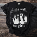 Black t-shirt with white text "girls will be girls" and witch silhouettes.