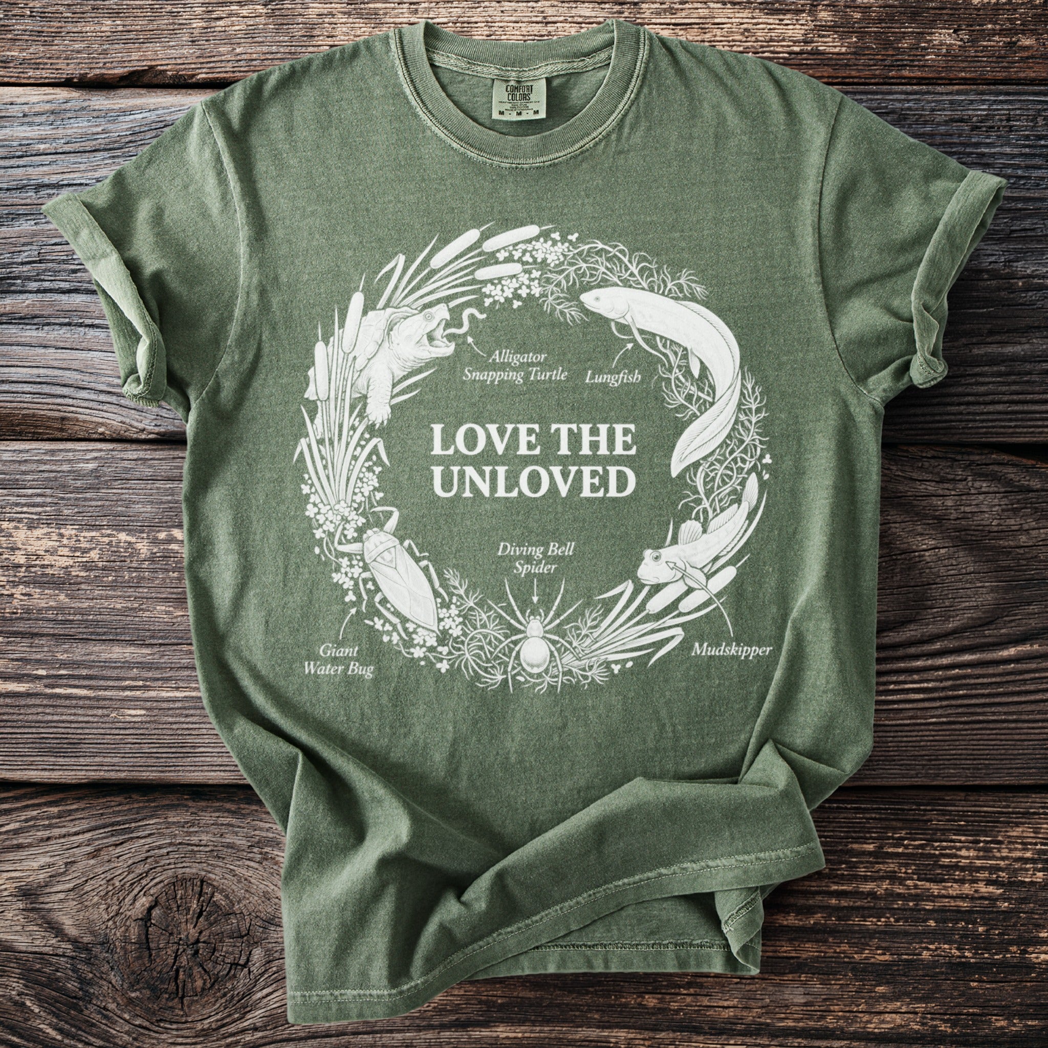Green t-shirt with white circular graphic of "love the unloved" and various aquatic animals.