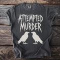 Dark grey t-shirt with "ATTEMPTED MURDER" text and two white crows.