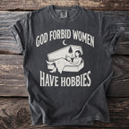 Dark grey t-shirt with white text "GOD FORBID WOMEN" and a coffin graphic with a person reading.