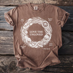 Brown t-shirt with white graphic of "LOVE THE UNLOVED" and various creatures in a circular design.