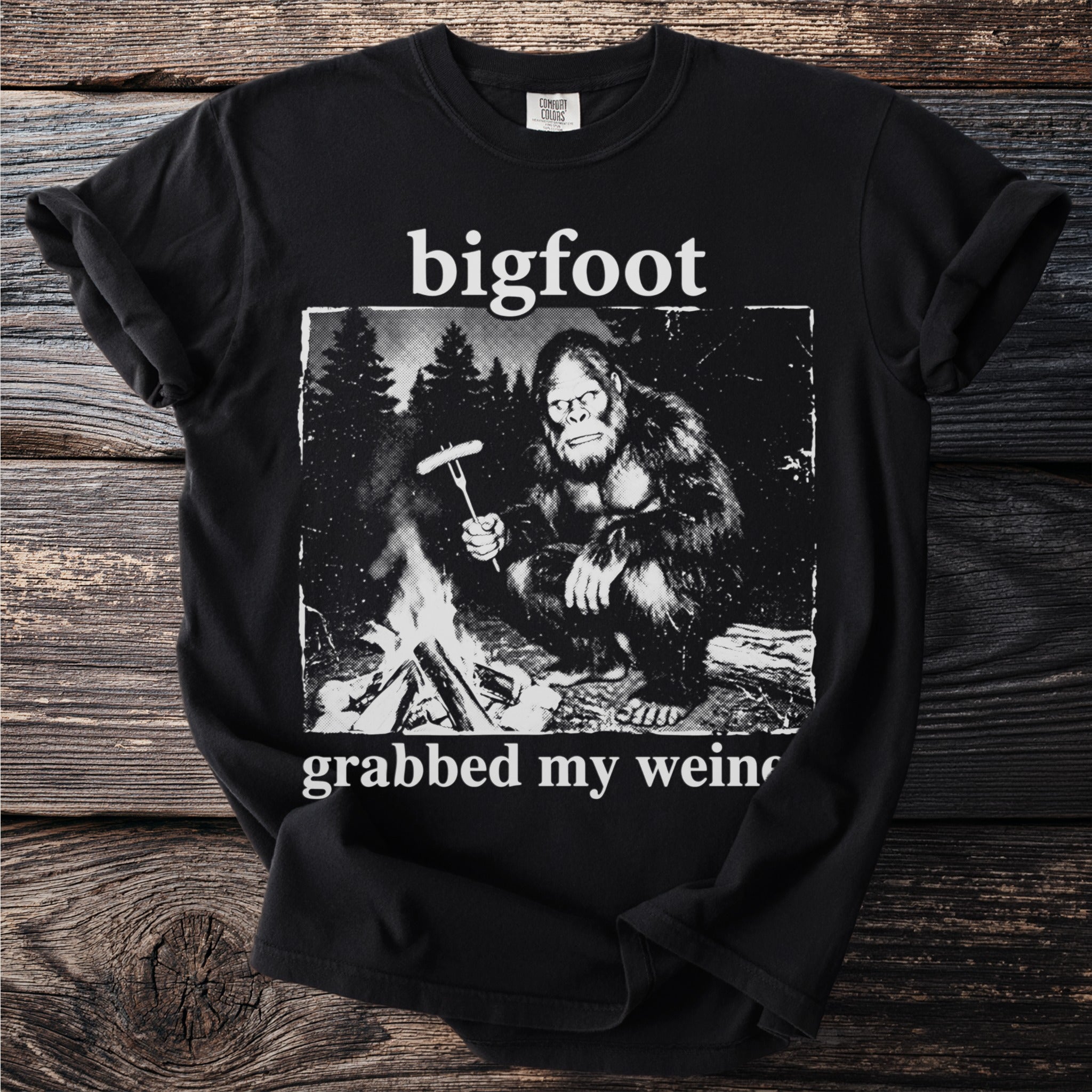 Bigfoot holding sausage on a fork by campfire with text "grabbed my wein(er)".
