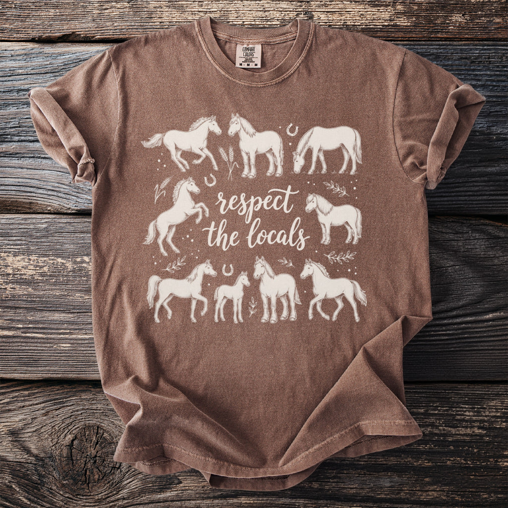 Brown t-shirt with white graphic of horses and text "respect the locals".