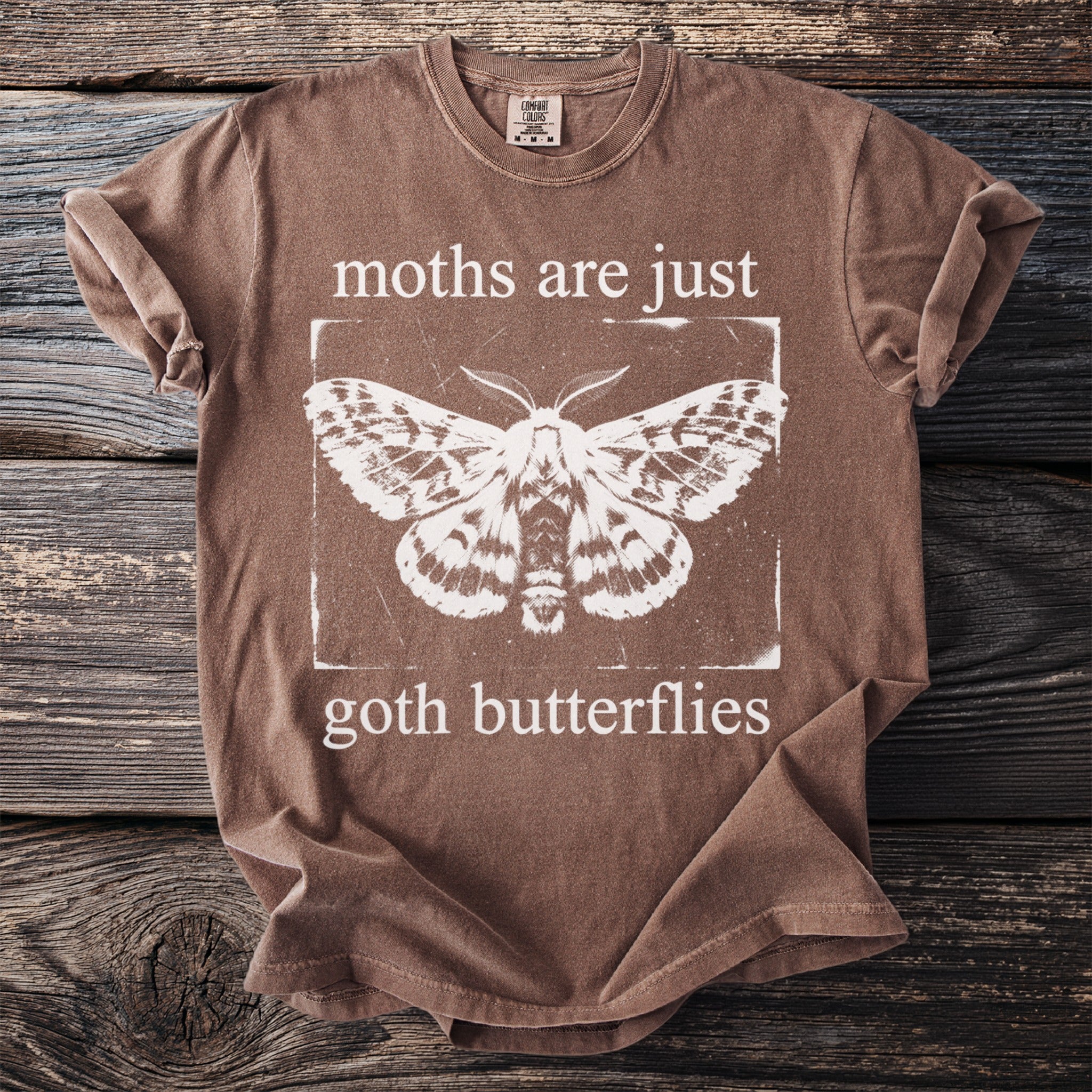 Brown t-shirt with white moth graphic and text "moths are just goth butterflies".