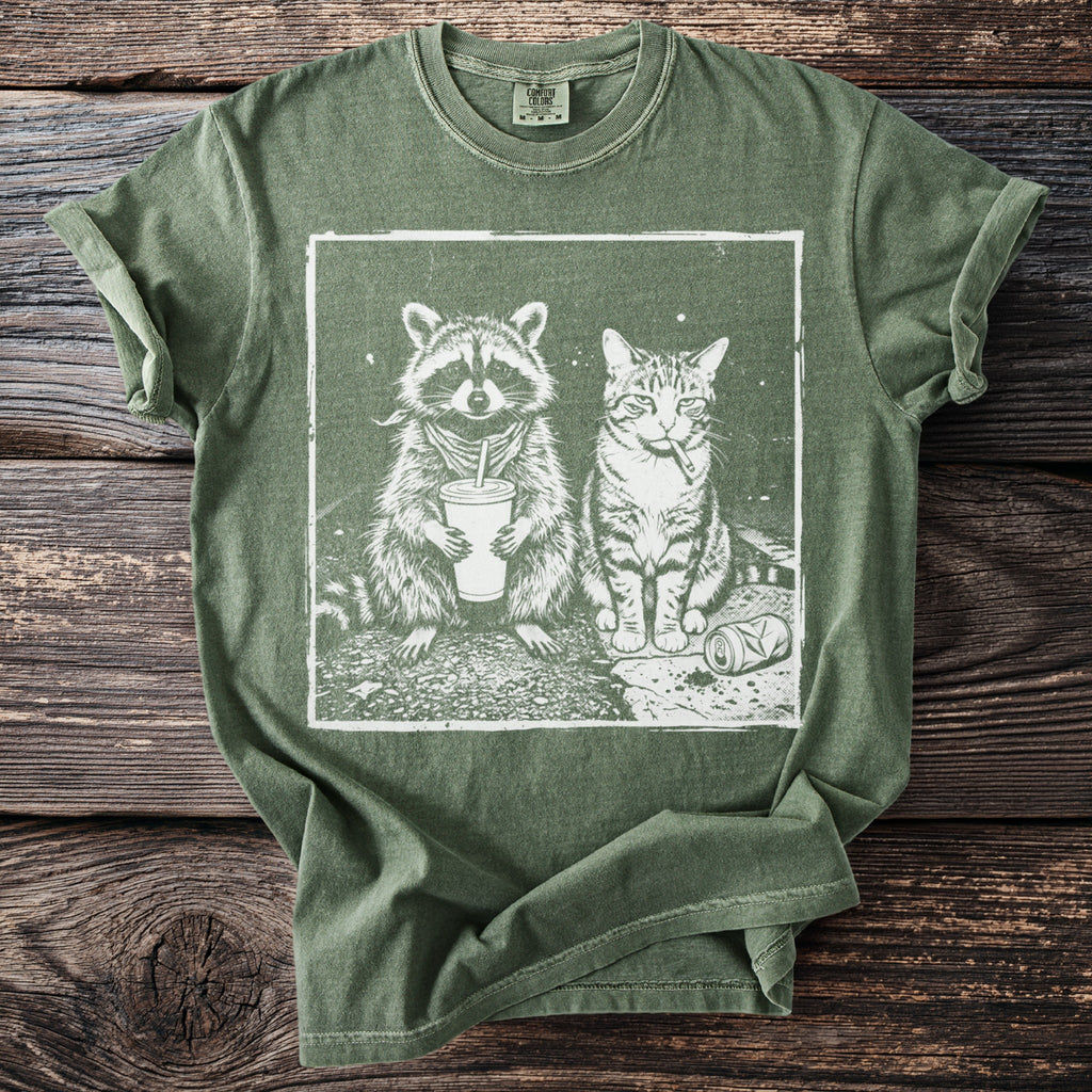 Green t-shirt featuring white graphic of raccoon with drink and cat smoking