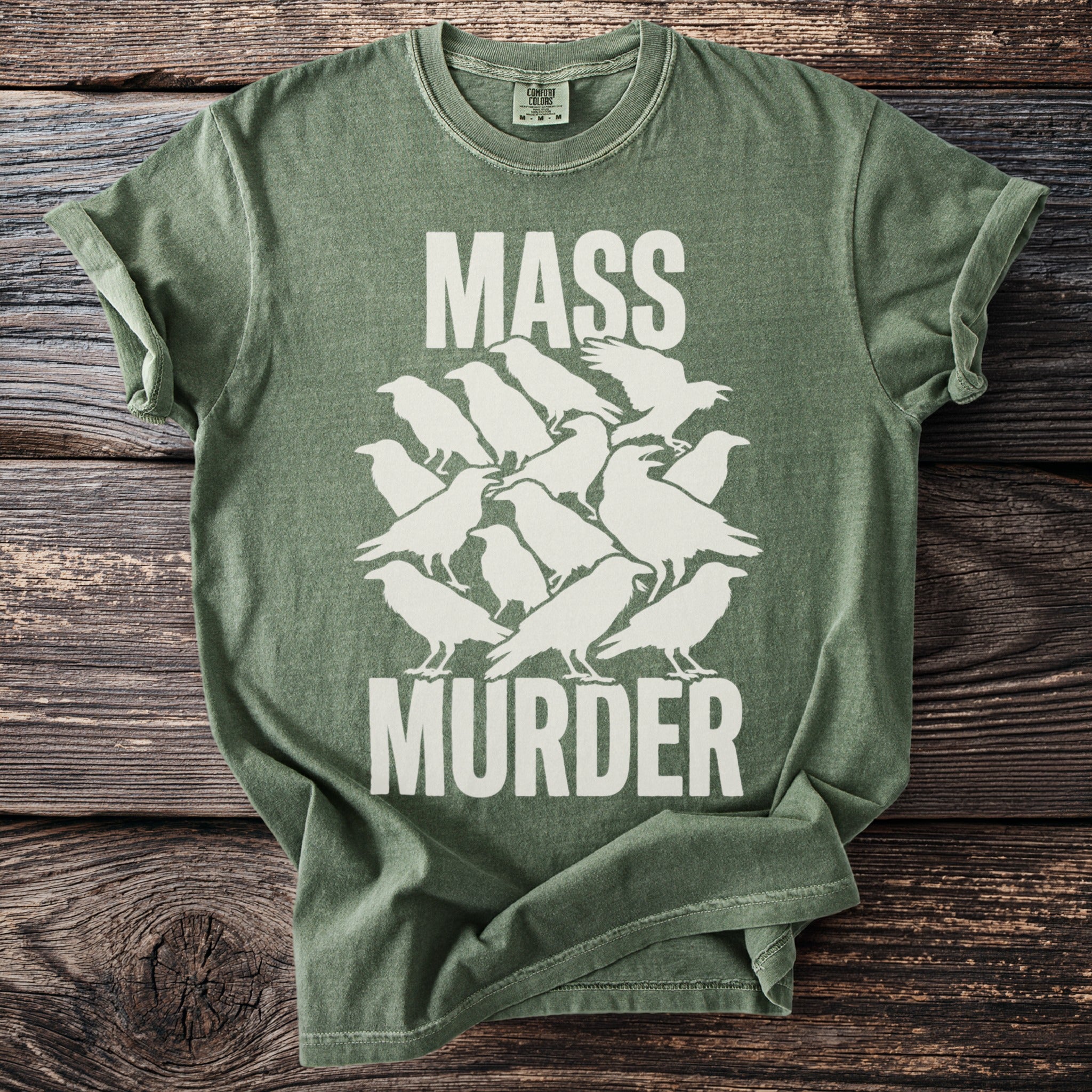 Green t-shirt with white text "MASS MURDER" and stylized crows.