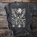 Charcoal t-shirt with a cream graphic of Mothman perched on a bridge under a full moon, with moths in the sky.