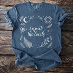 Blue t-shirt with white celestial and floral design and text "respect the locals".
