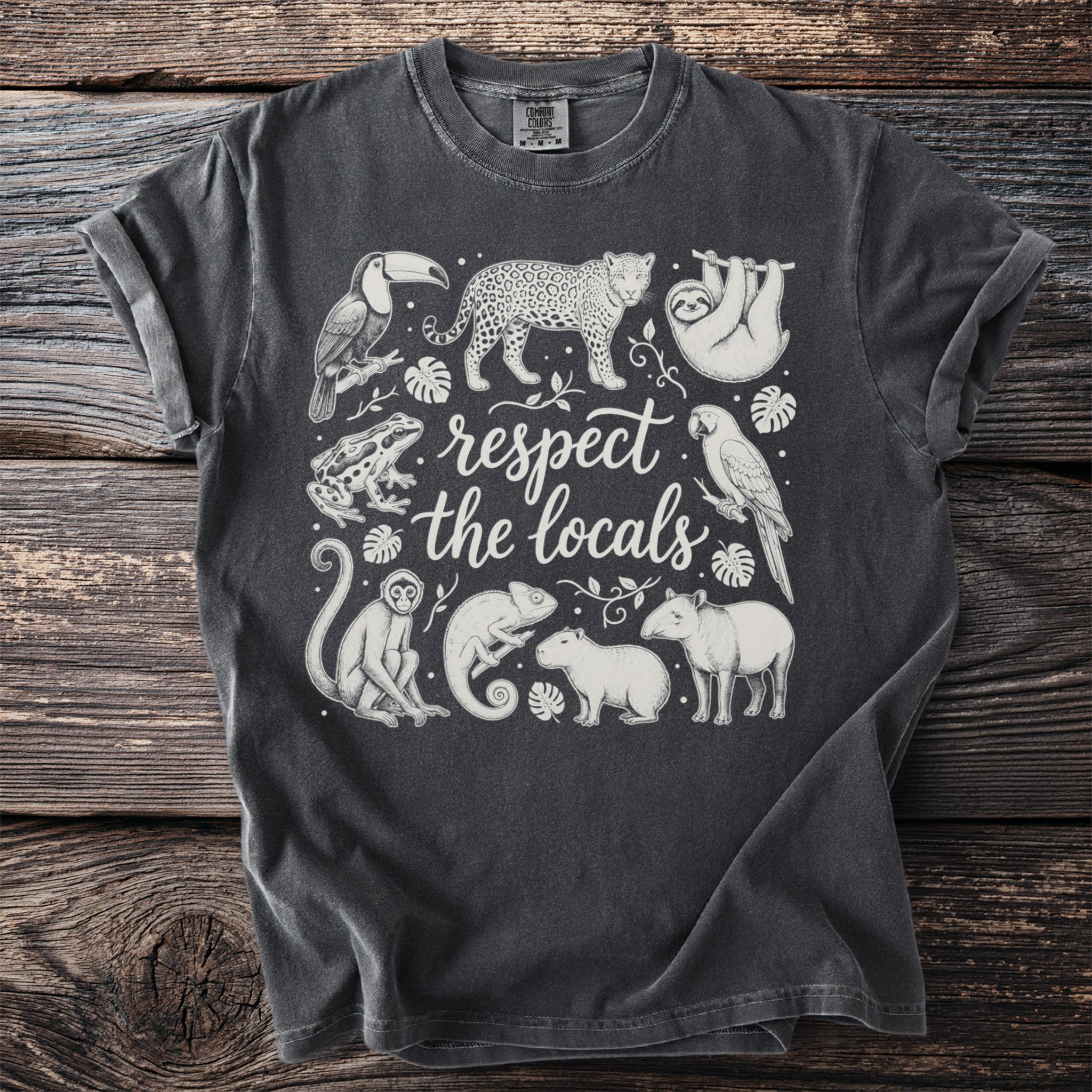 T-shirt with "respect the locals" text and illustrations of rainforest animals.