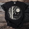 Black t-shirt with circular graphic of birch trees, lantern, moon, and birds over a lake.