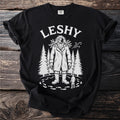 Black t-shirt with white graphic of Leshy, trees, and a small figure.