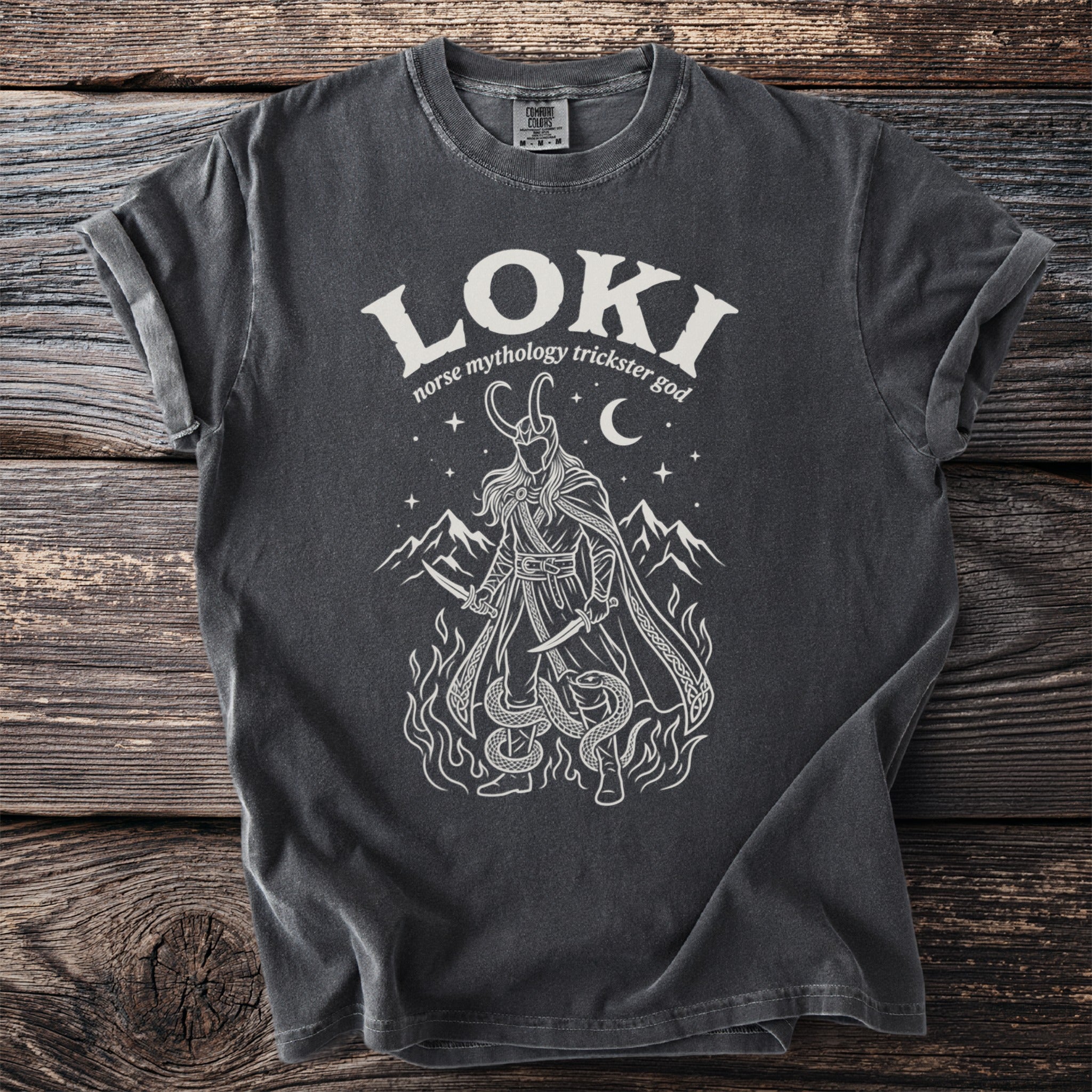 Dark grey t-shirt with white graphic of Loki, mountains and snakes.
