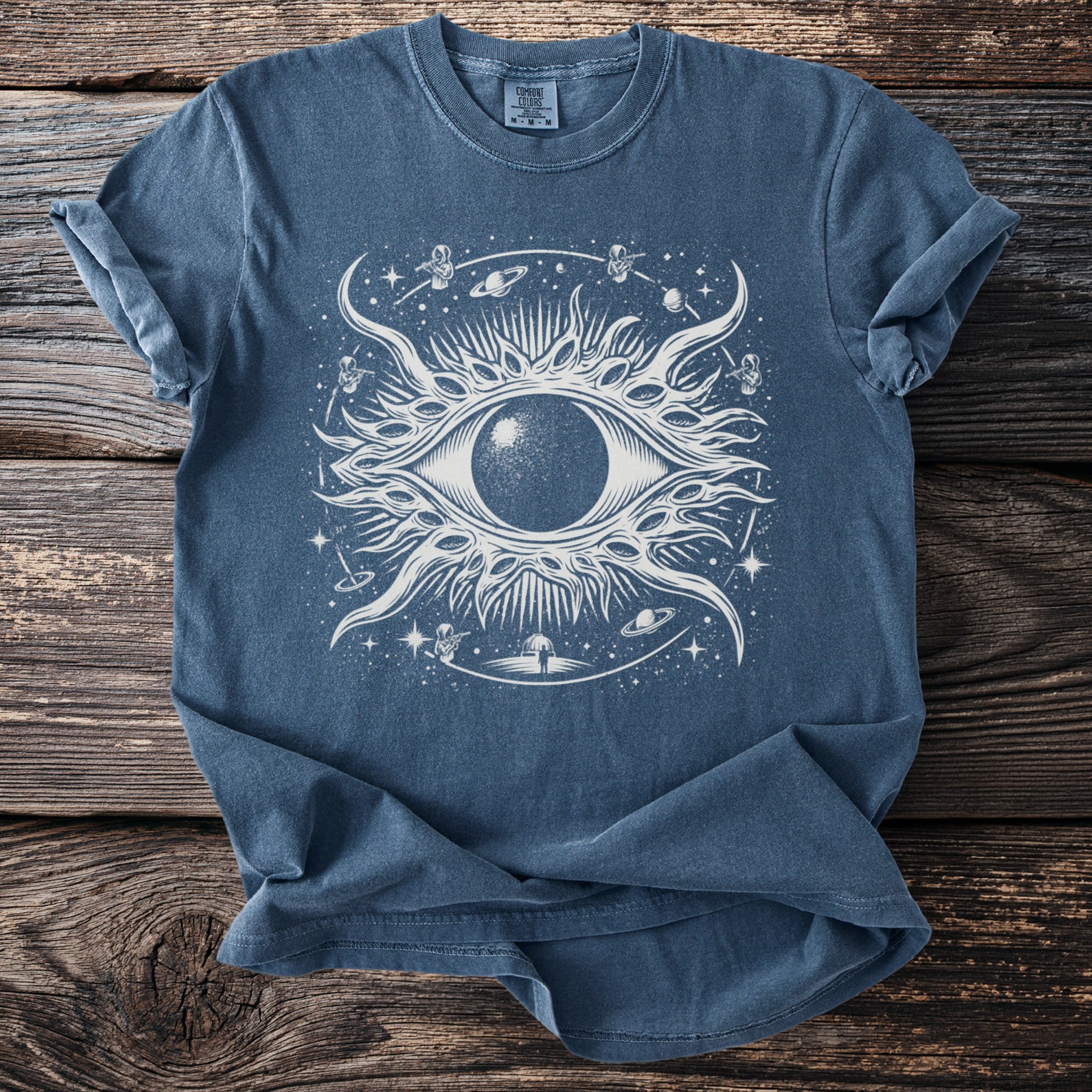 Blue t-shirt with a white cosmic eye graphic and astronauts.