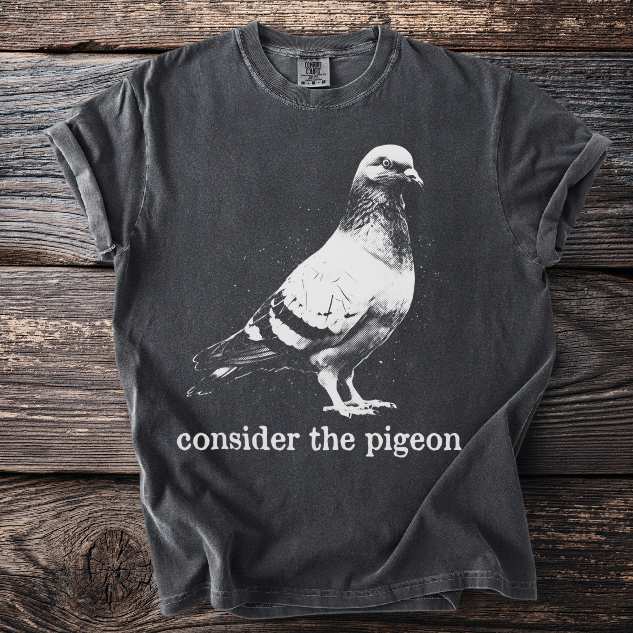 Dark grey t-shirt with "consider the pigeon" text and a pigeon graphic.