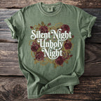 Green t-shirt with "Silent Night Unholy Night" text and rose graphic.