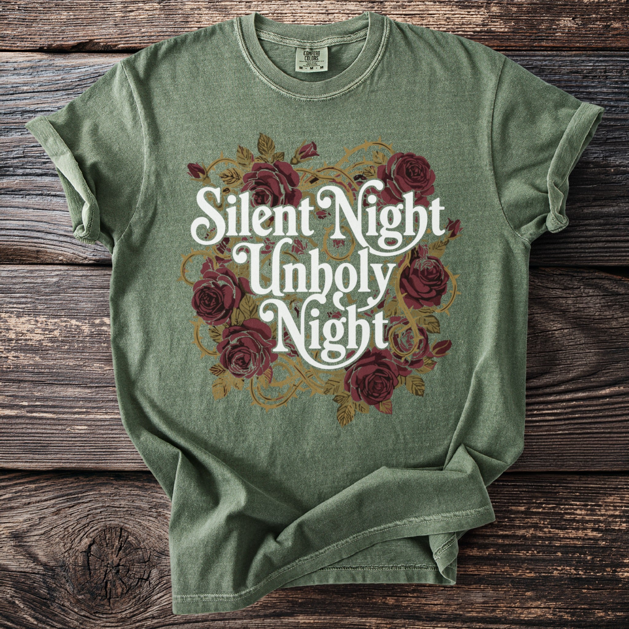 Green t-shirt with "Silent Night Unholy Night" text and rose graphic.