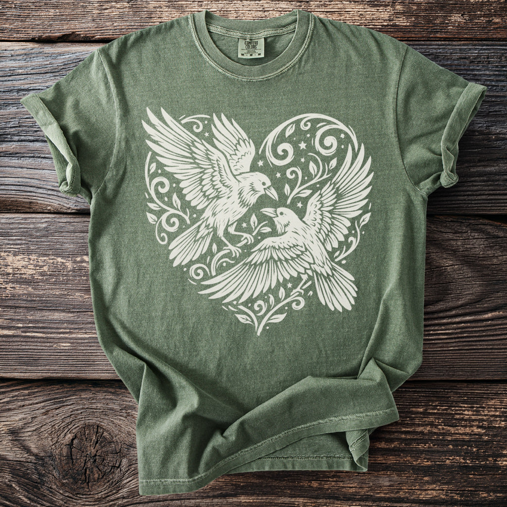Green t-shirt with white print of two birds and a heart design.