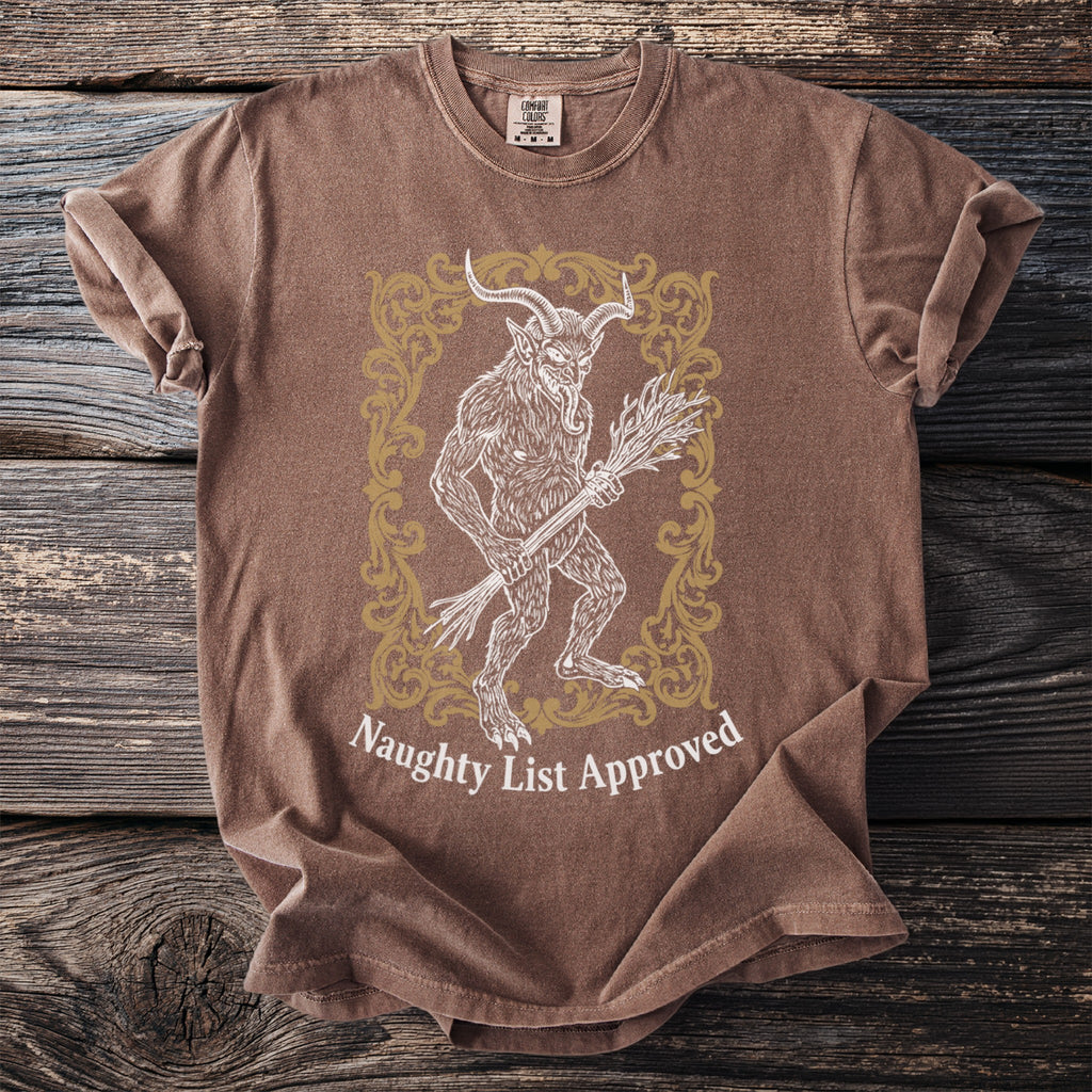Brown t-shirt with a Krampus illustration and "Naughty List Approved" text.