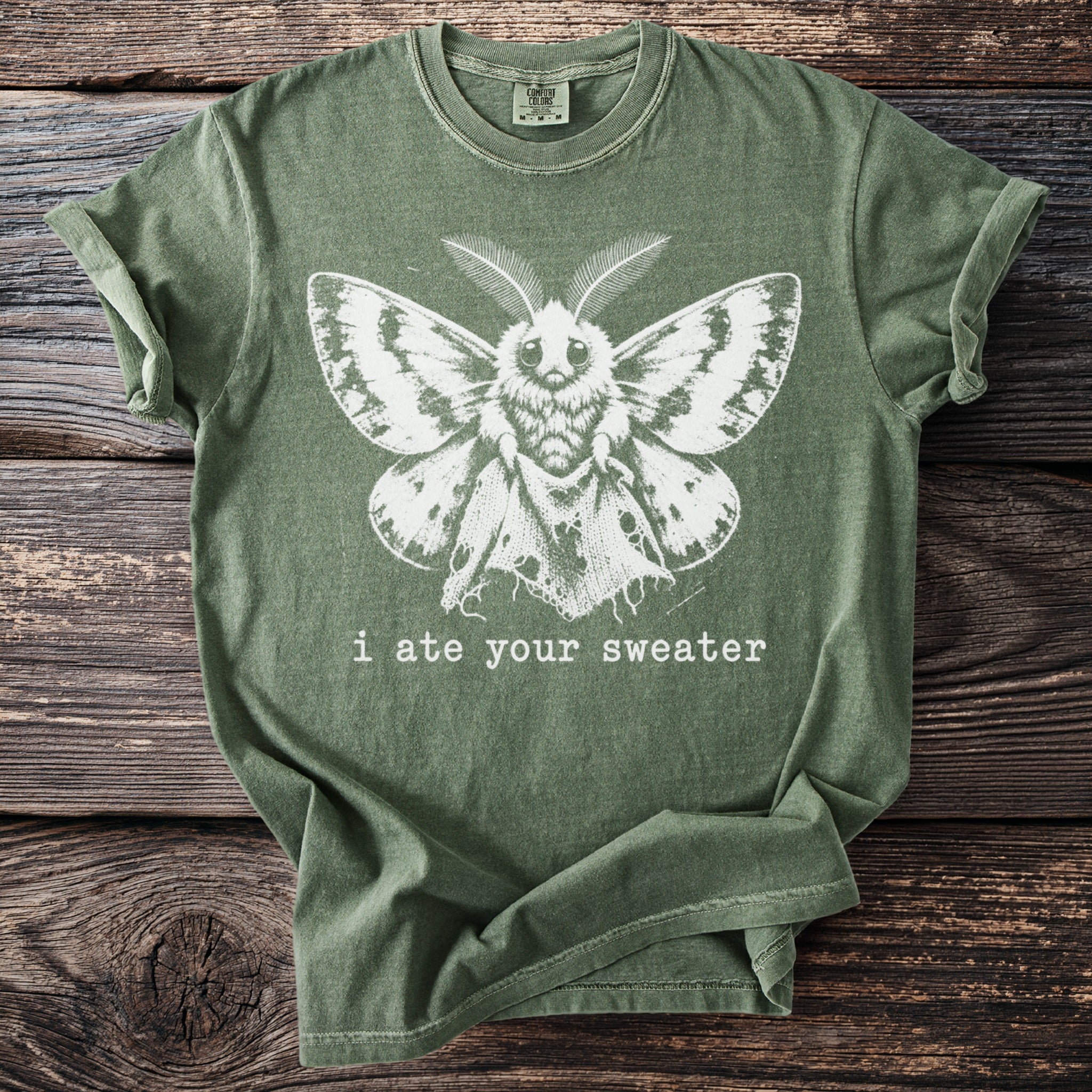 Green t-shirt with a distressed white moth graphic and text: "i ate your sweater."
