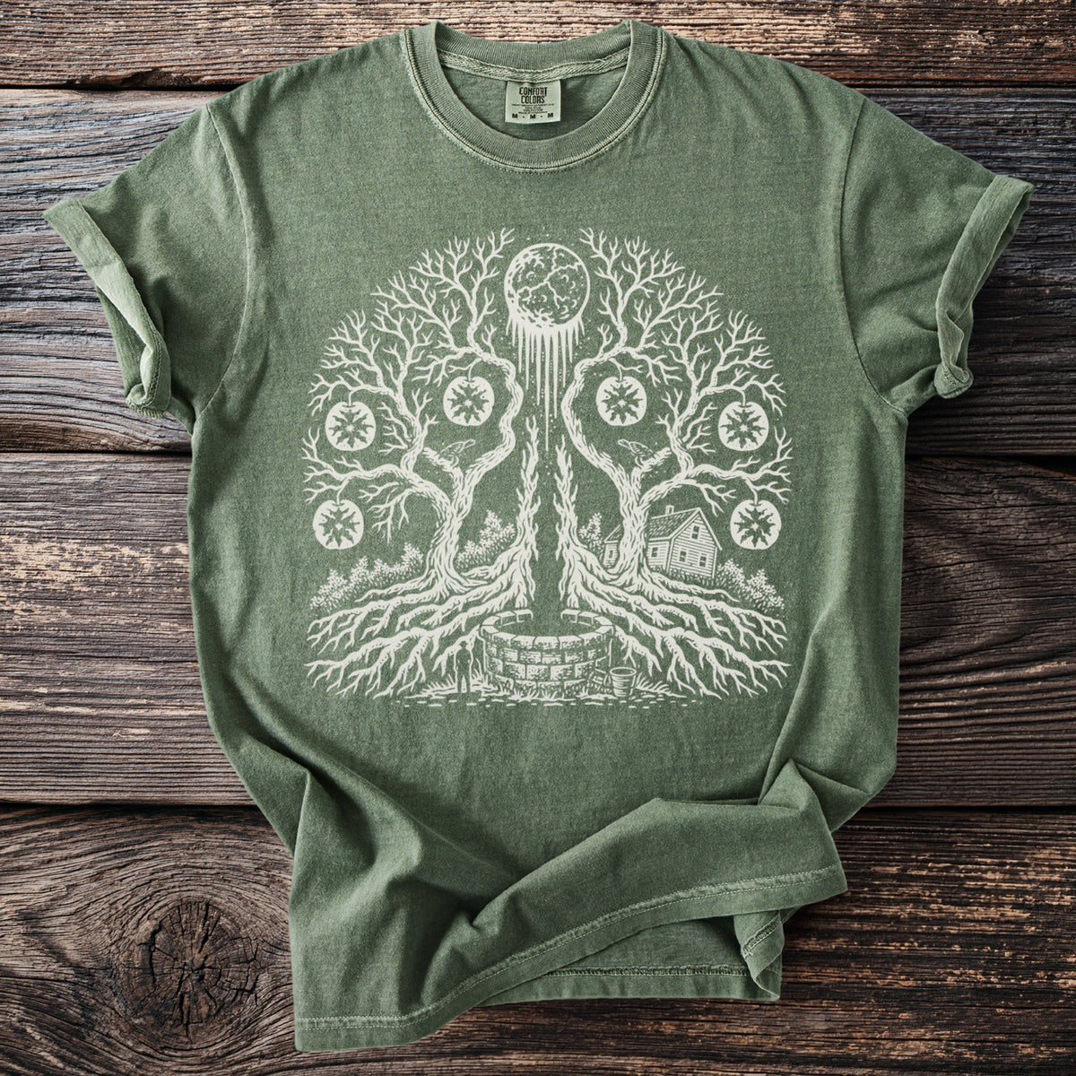 Green t-shirt with white graphic of a tree with roots, a well, a house, and a moon.