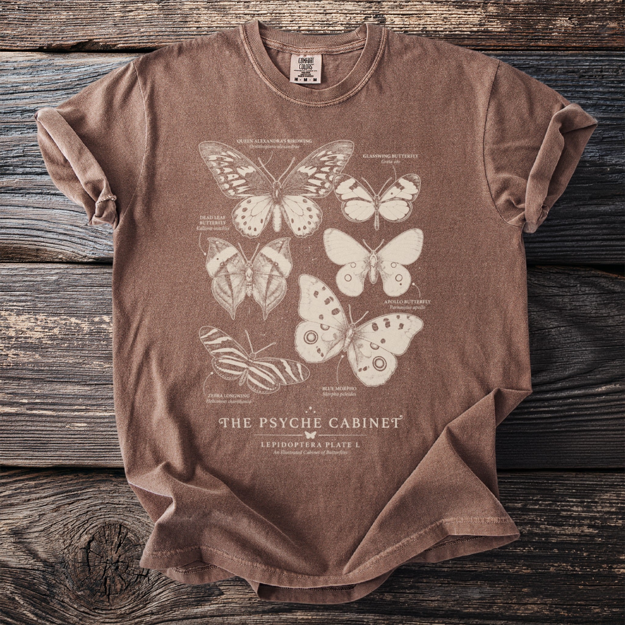 Brown t-shirt with "The Psyche Cabinet" and illustrations of various butterflies.