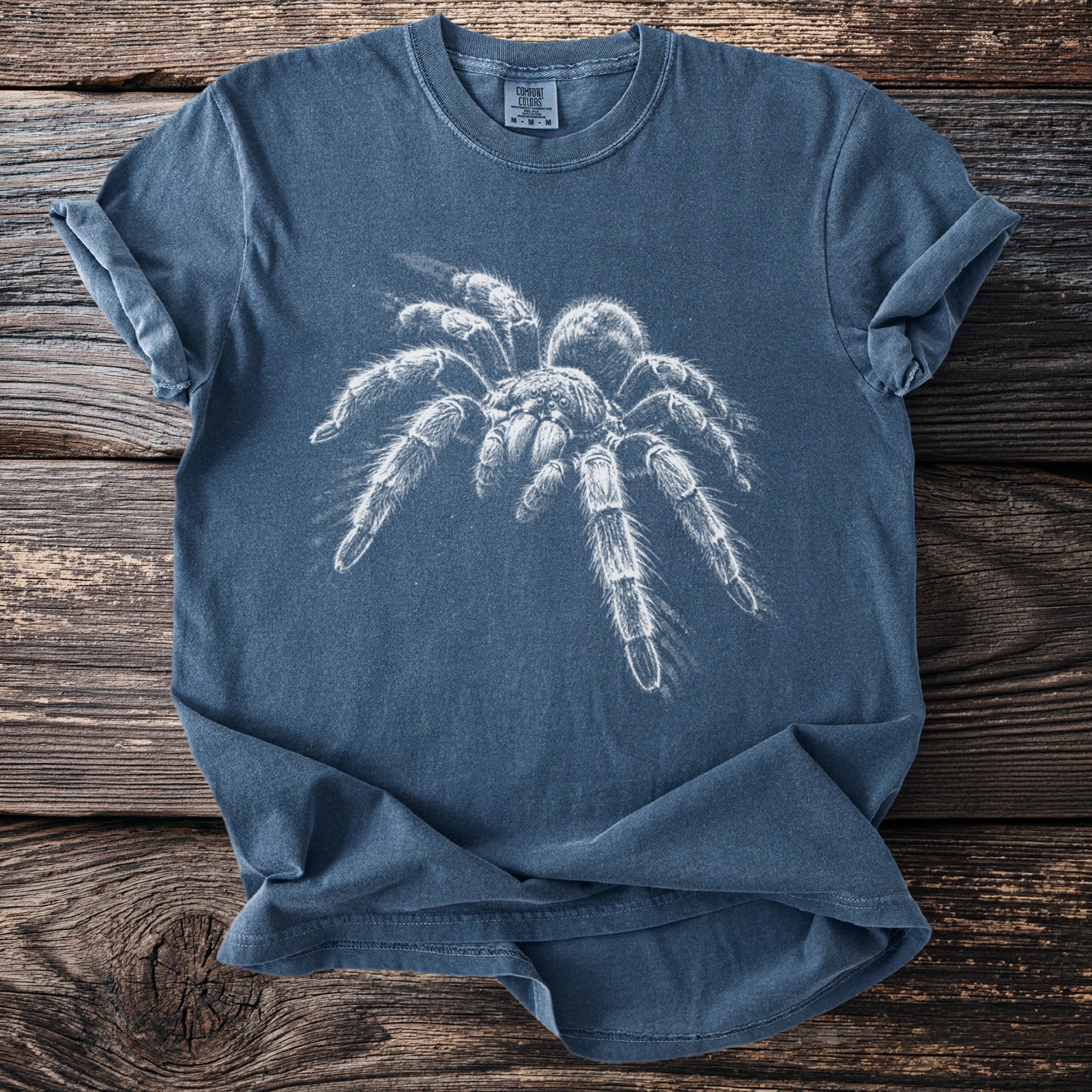 Blue t-shirt with a white tarantula graphic and Comfort Colors tag.