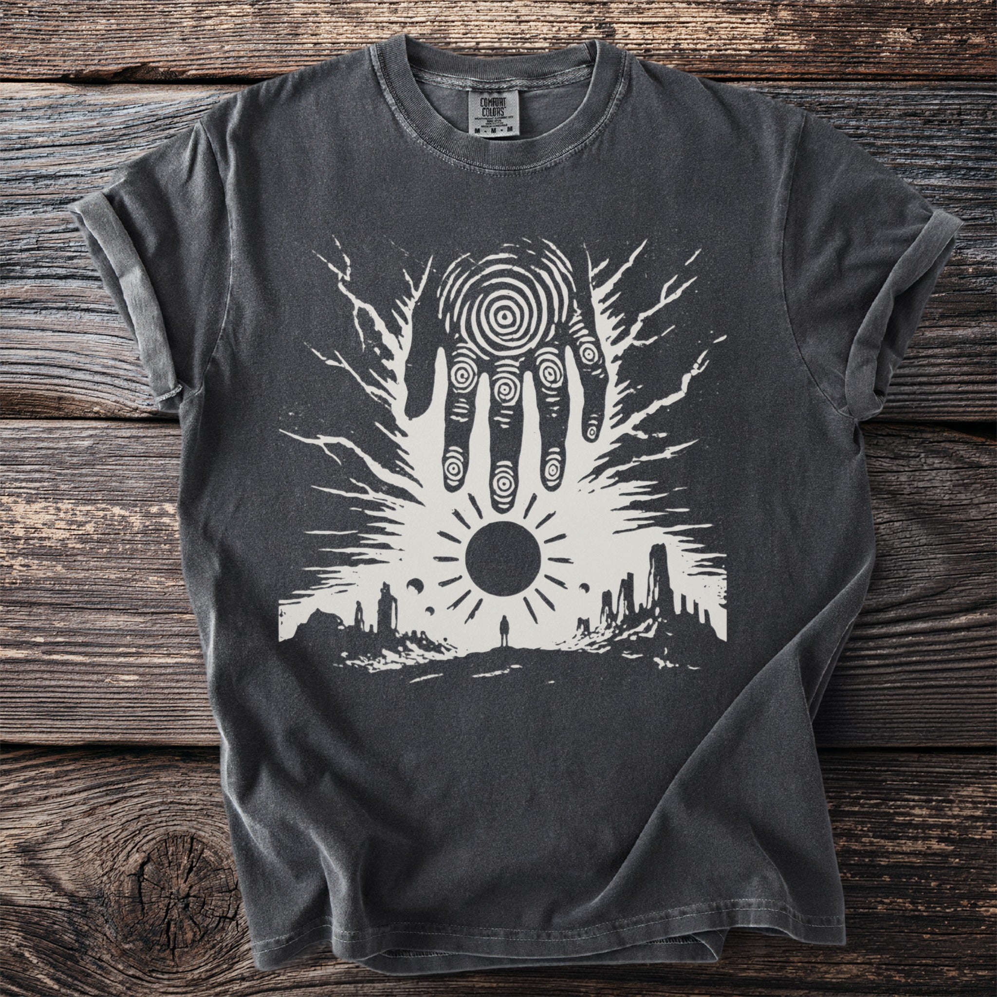 Dark grey t-shirt with a white graphic of a hand, sun, and landscape.