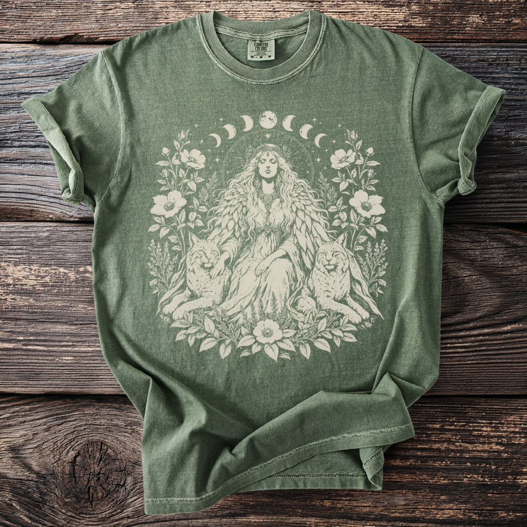 Green t-shirt with a celestial goddess, wolves, and floral design.