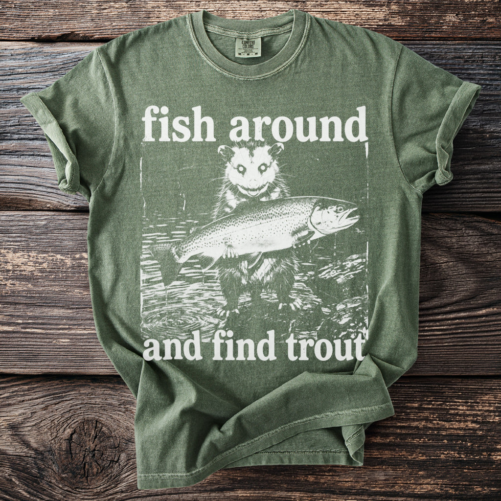 Green t-shirt with white graphic of possum holding a trout and text "fish around and find trout".