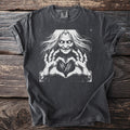 Dark t-shirt with a black and white illustration of a witch making a heart shape with her hands.