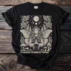 Black t-shirt with a pagan-themed graphic featuring a woman with moth wings, moon, mushrooms, and roses.