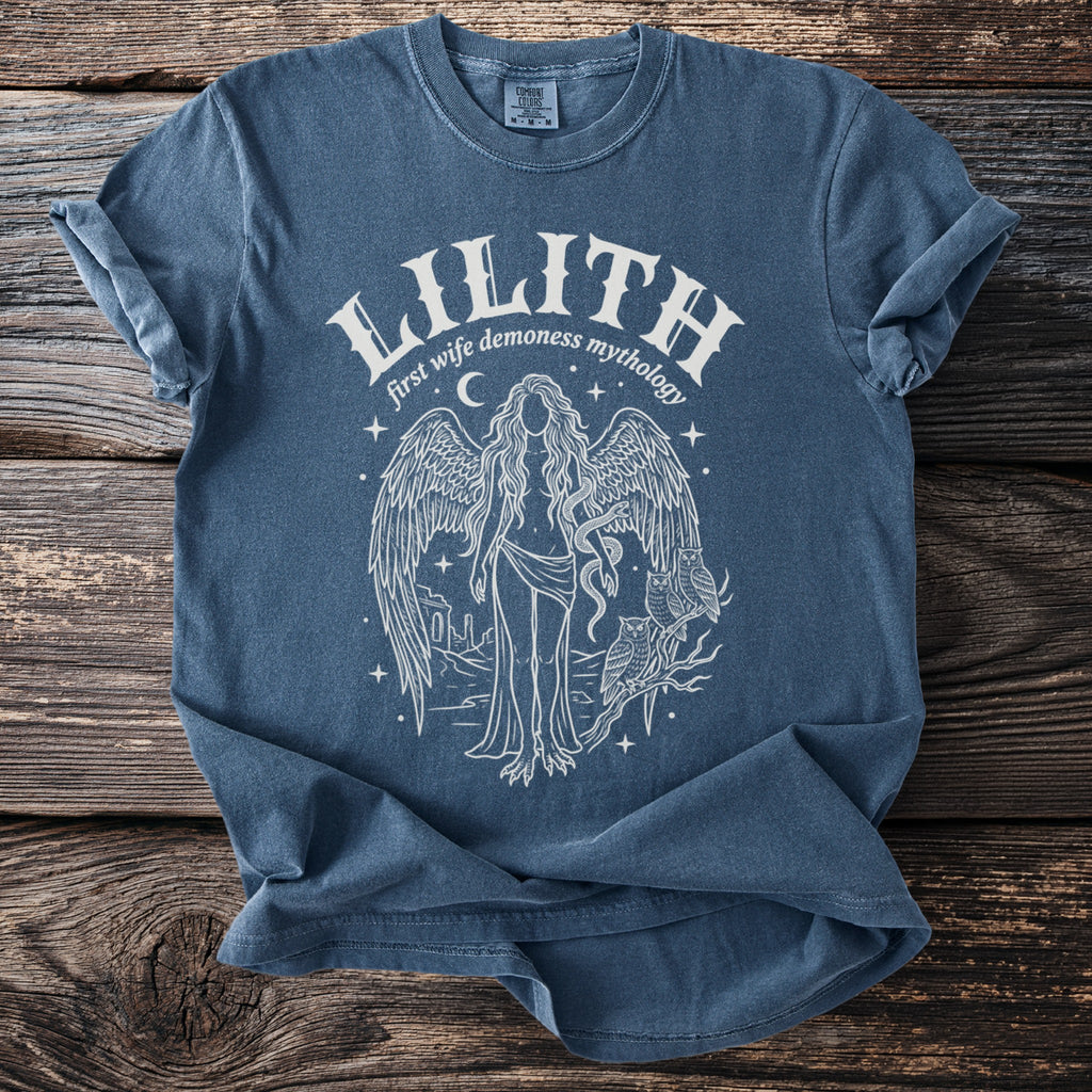 Blue t-shirt with "Lilith first wife demoness mythology" and an illustration of a winged figure.