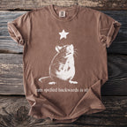 Brown t-shirt with a white distressed graphic of a rat and a star above it, reading "rats spelled backwards is star."
