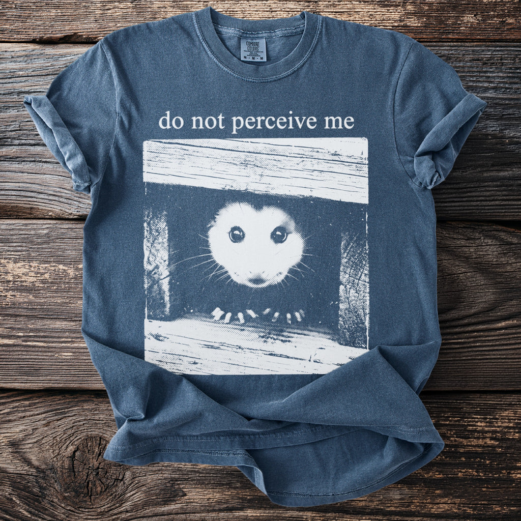 Blue t-shirt with possum graphic and text "do not perceive me".