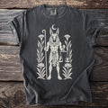 Dark grey t-shirt featuring Anubis with scales and plants in cream print.