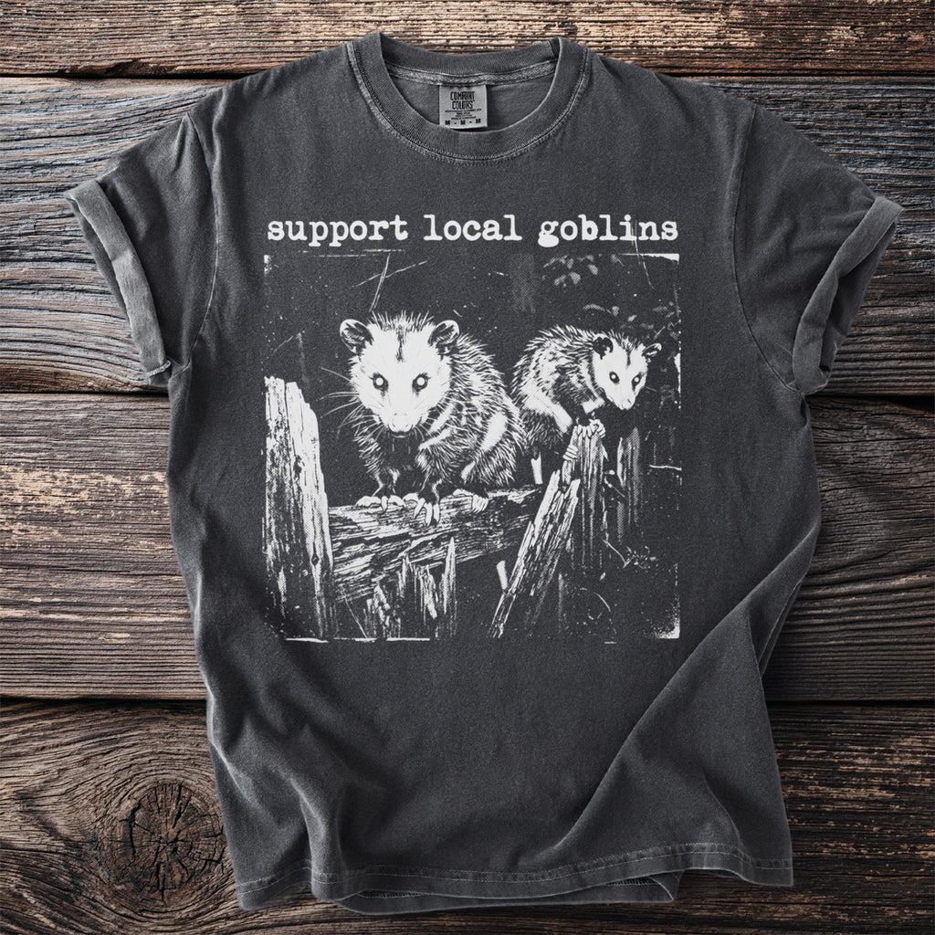 Dark gray t-shirt with white graphic and text "support local goblins".