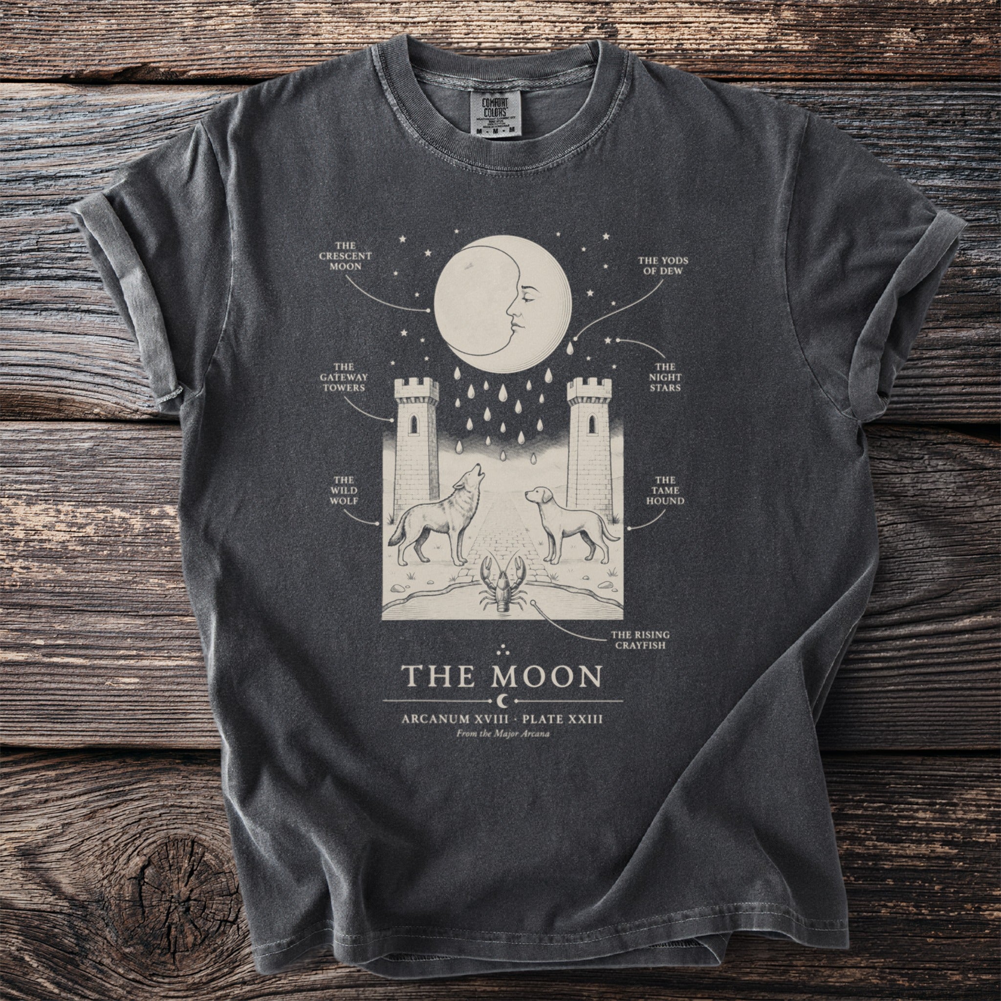Dark grey t-shirt with "The Moon" artwork depicting a crescent moon, towers, wolf, dog, and lobster.