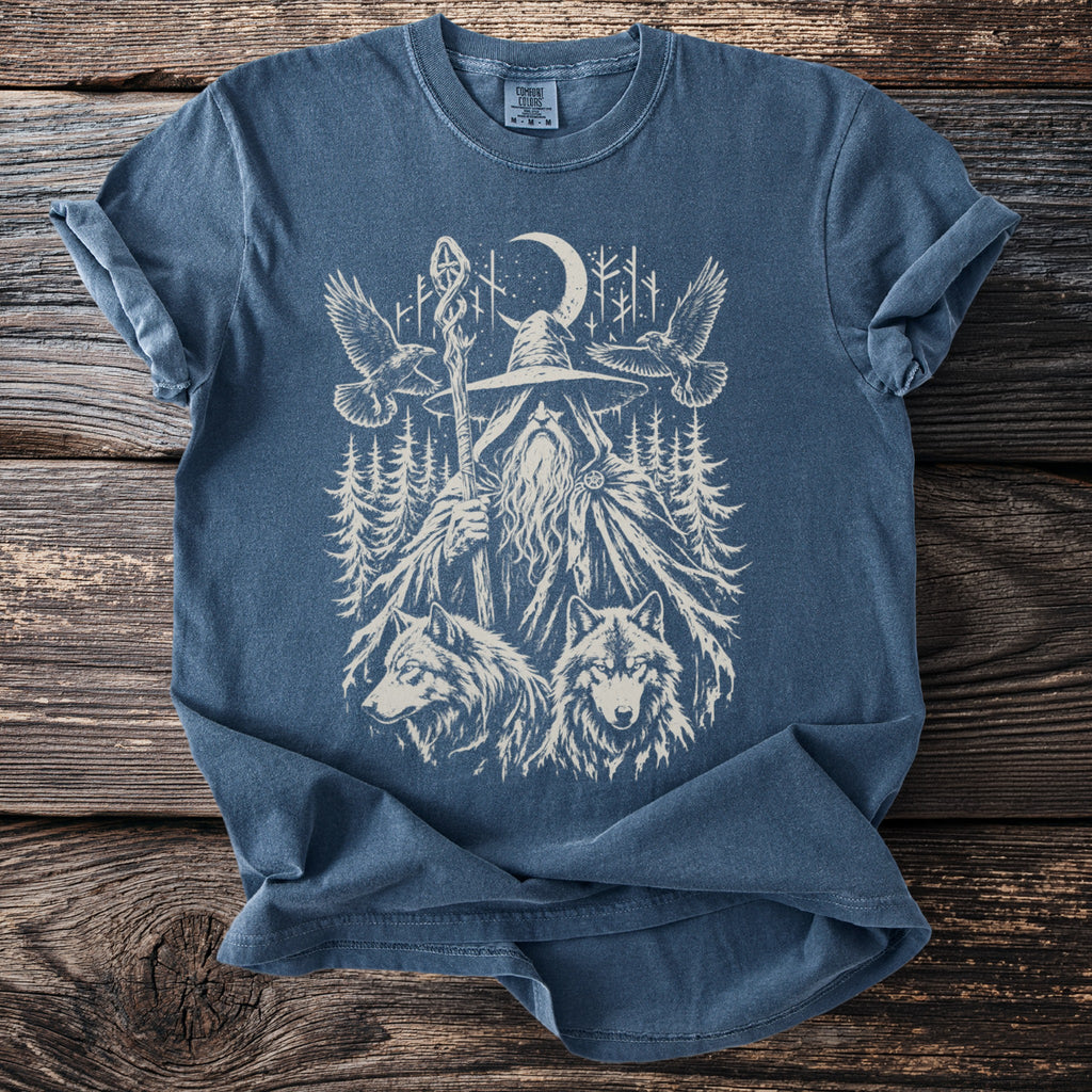 Blue t-shirt with graphic of wizard, wolves, eagles, and moon in forest.