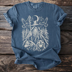 Blue t-shirt with graphic of wizard, wolves, eagles, and moon in forest.