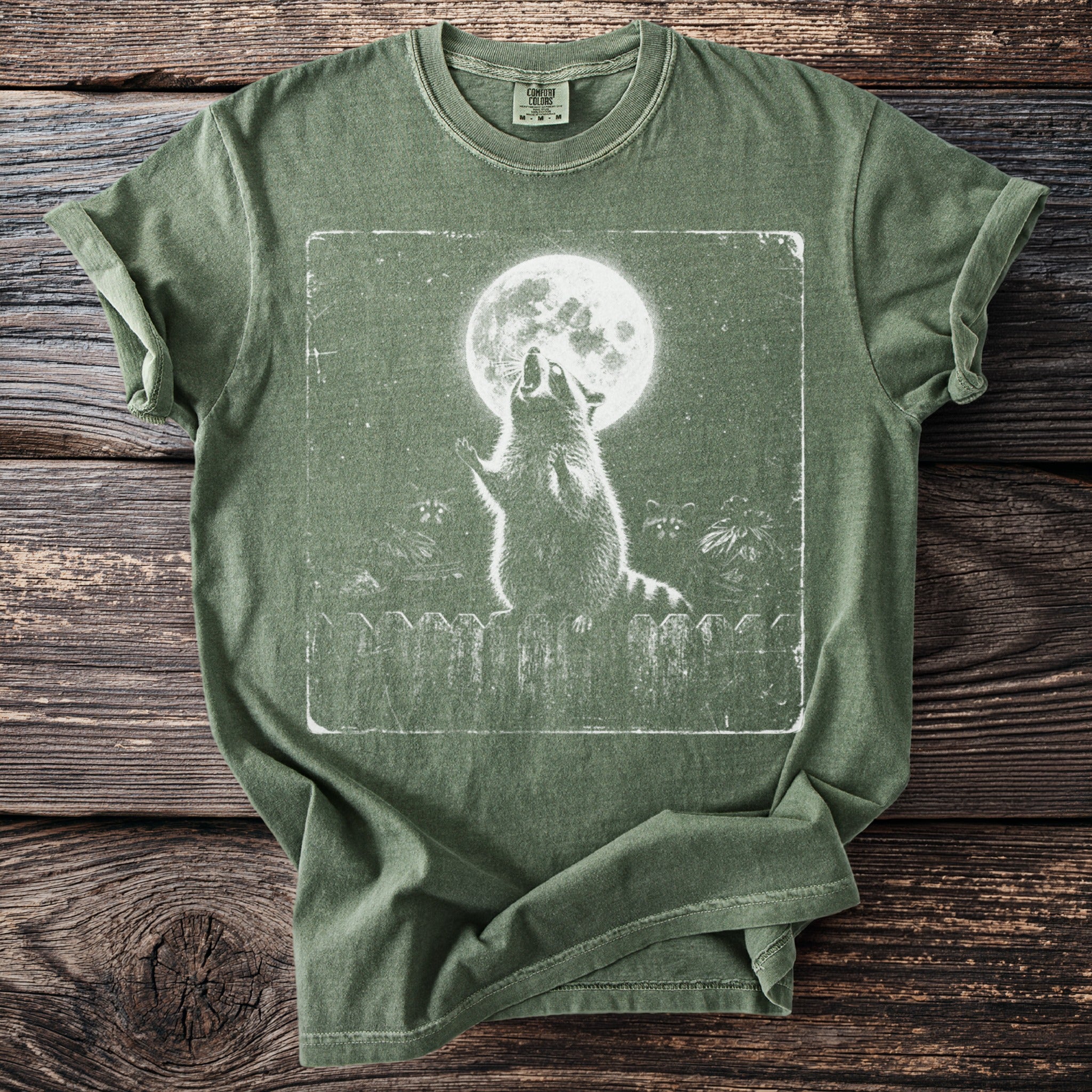 Green Comfort Colors t-shirt with a distressed raccoon howling at the moon graphic.