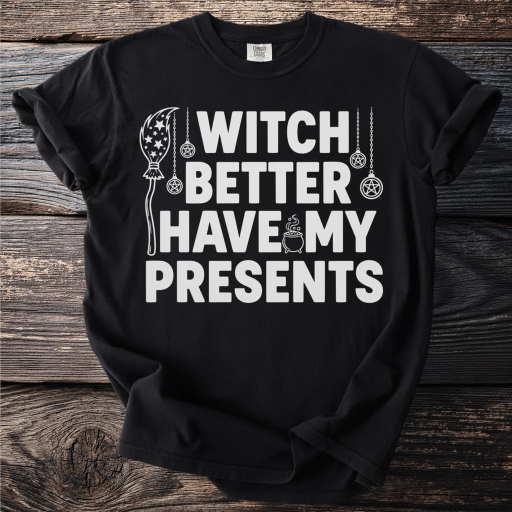 Black t-shirt with white text "WITCH BETTER HAVE MY PRESENTS" and witchy graphics.